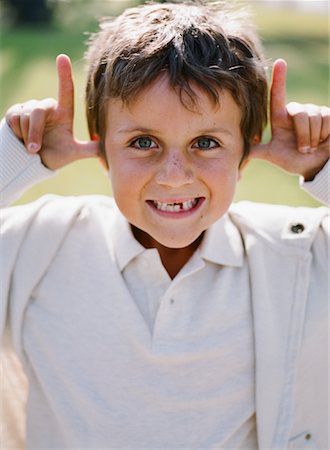 Boy Sticking Making Faces, Huntington Beach, California, USA Foto de stock - Con derechos protegidos, Código: 700-02063371
