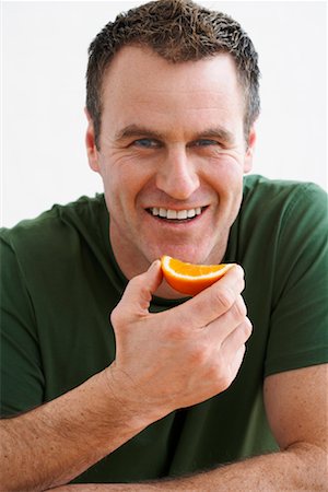 people with fruits cutout - Man Eating Orange Stock Photo - Rights-Managed, Code: 700-02071539