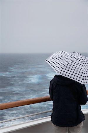 sad rainy day - Woman with Umbrella on Cruise Ship Deck Stock Photo - Rights-Managed, Code: 700-02082056