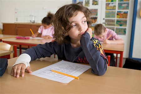 Boy Daydreaming while other Students Take Test Stock Photo - Rights-Managed, Code: 700-02217425
