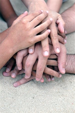 Close-up of Hands Piled on Top of One Another on the Beach Stock Photo - Rights-Managed, Code: 700-02235839