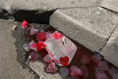 Gros plan des coeurs en papier dans une flaque d'eau sur le côté de la route, Arles, France Photographie de stock - Rights-Managed, Code: 700-02245695