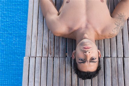 Man Lying Down by Swimming Pool Stock Photo - Rights-Managed, Code: 700-02264878