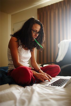 Femme utilisant un ordinateur portable dans la chambre d'hôtel Photographie de stock - Rights-Managed, Code: 700-02265424