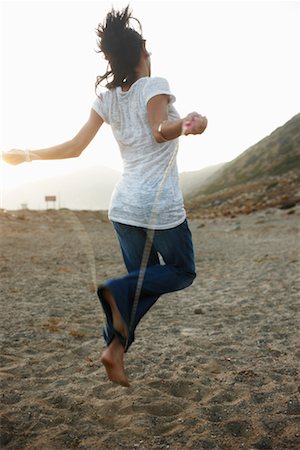 puéril - Femme sautant sur la plage Photographie de stock - Rights-Managed, Code: 700-02265422