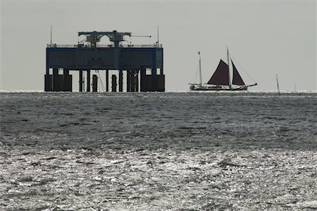 petróleo e gasolina - Flat-Bottomed Sailboat Near Offshore Platform, Wadden Sea, Friesland, Netherlands Foto de stock - Direito Controlado, Número: 700-02265779