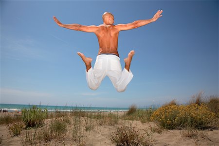 people jumping into water back view - Man Jumping on Beach Foto de stock - Con derechos protegidos, Código: 700-02289275