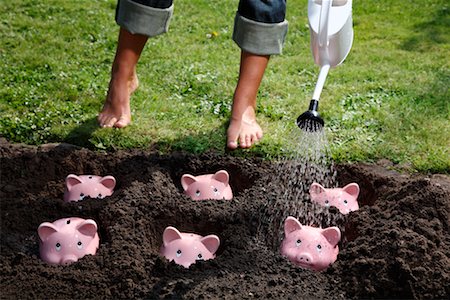 simsearch:700-02289305,k - Woman Watering Piggy Banks Foto de stock - Con derechos protegidos, Código: 700-02289304