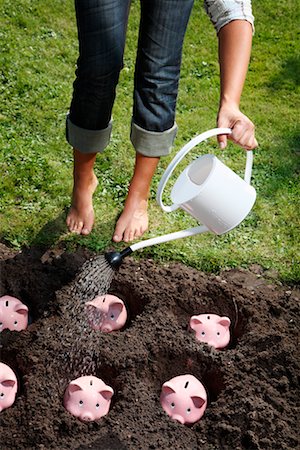 Woman Watering Piggy Banks Foto de stock - Con derechos protegidos, Código: 700-02289306