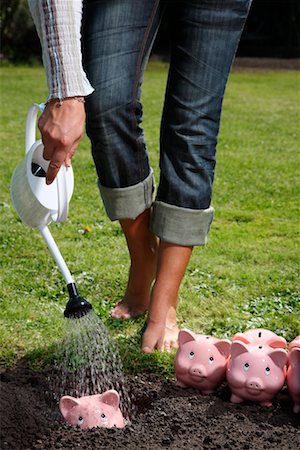 Woman Watering Piggy Banks Stock Photo - Rights-Managed, Code: 700-02289303