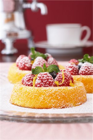 simsearch:700-02347869,k - Sugar-Coated Raspberry Shortcakes With Mint, Blueberries and Lemon Zest, With Coffee Cups and Pot in the Background Stock Photo - Rights-Managed, Code: 700-02347863