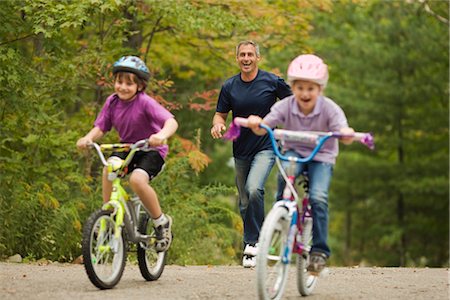 father being chased by kids - Girls on Bikes Riding Away From Their Father Stock Photo - Rights-Managed, Code: 700-02348978