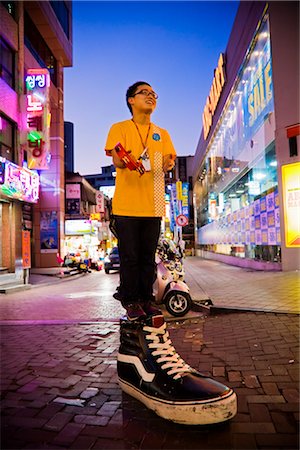 Boy Standing on Sculpture of Shoe, Myeong-dong Shopping Area, Seoul, South Korea Foto de stock - Con derechos protegidos, Código: 700-02370967