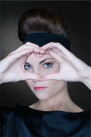 Portrait of Woman Making the Shape of a Heart With Her Hands Foto de stock - Direito Controlado, Número: 700-02637533