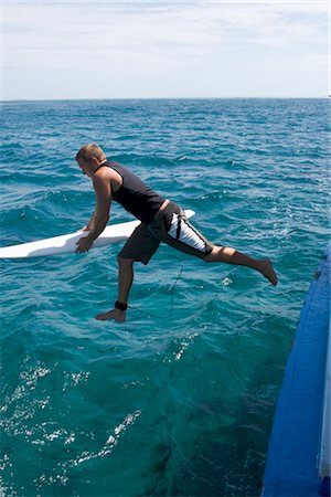 Surfer Jumping Off Boat Into Sea at Chickens Surf Break, North Male Atoll, Maldives Fotografie stock - Rights-Managed, Codice: 700-02670170