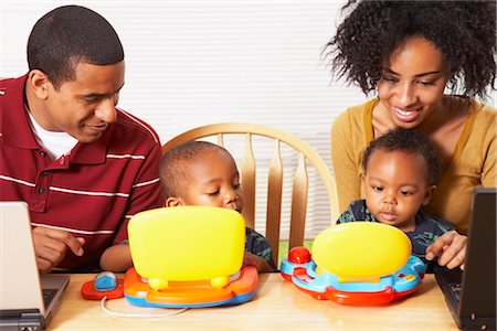 Mère et père, à l'aide d'ordinateurs portables, les fils à l'aide d'ordinateurs de jouet Photographie de stock - Rights-Managed, Code: 700-02686570