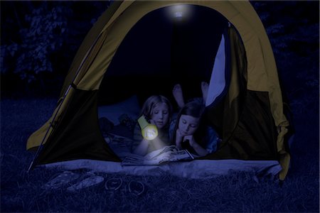 sleepovers - Girls in Tent at Night, Using Flashlight to Read Magazine Stock Photo - Rights-Managed, Code: 700-02698417