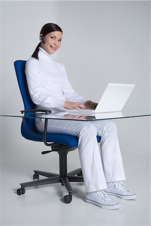 Woman Sitting at Desk using Laptop Computer Foto de stock - Con derechos protegidos, Código: 700-02693761