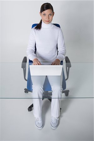 Portrait of Woman Sitting at a Desk in an Ergonomic Chair, Using Laptop Computer Stock Photo - Rights-Managed, Code: 700-02693774