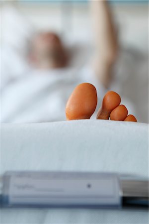 foot exam - Male Patient Lying in Hospital Bed Stock Photo - Rights-Managed, Code: 700-02700901