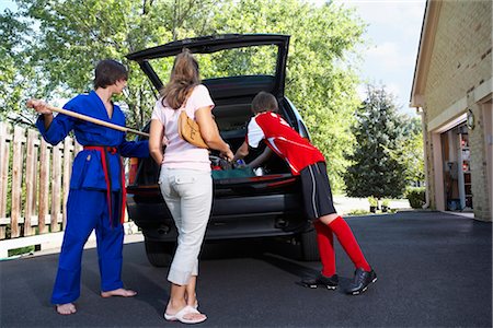 Garçons en karaté et football uniformes aident le Pack Mom la voiture Photographie de stock - Rights-Managed, Code: 700-02738850