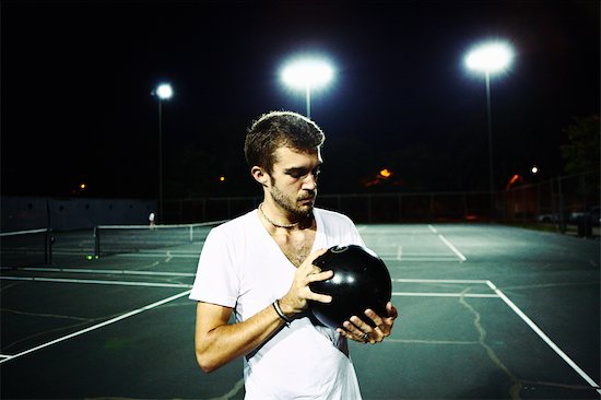 Man Standing on Tennis Court Holding Bowling Ball Stock Photo - Premium Rights-Managed, Artist: Nathan Jones, Image code: 700-02786846