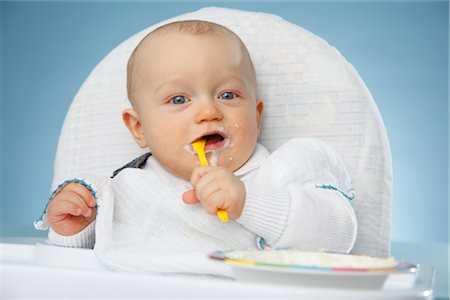 Baby Boy in High Chair Eating Foto de stock - Con derechos protegidos, Código: 700-02833381