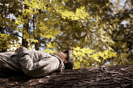 Homme couché sur le tronc d'arbre Photographie de stock - Rights-Managed, Code: 700-02833457