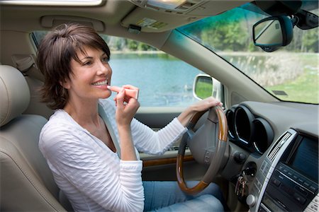 Driver Putting on Lip Gloss Stock Photo - Rights-Managed, Code: 700-02833584