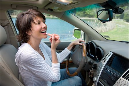 Driver Putting on Lip Gloss Stock Photo - Rights-Managed, Code: 700-02833583