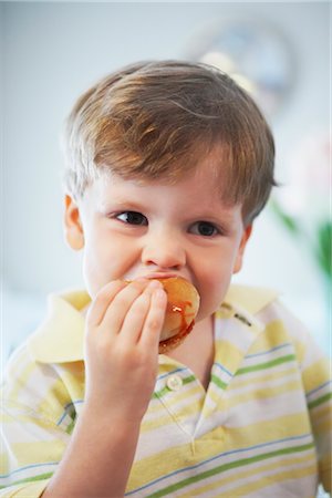 Close-up of Boy Eating Doughnut Foto de stock - Con derechos protegidos, Código: 700-02833652