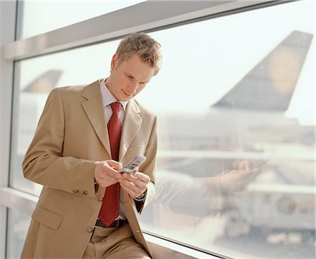Businessman using Cell Phone at Airport Stock Photo - Rights-Managed, Code: 700-02887166