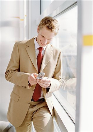 Businessman using Cell Phone at Airport Stock Photo - Rights-Managed, Code: 700-02887172