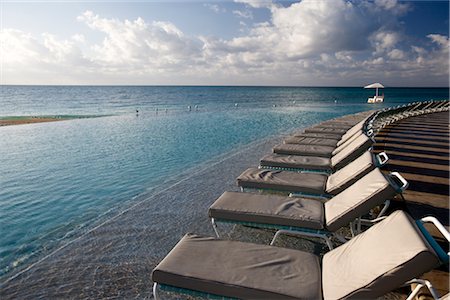 row of beach chairs - Lounge Chairs by Infinity Pool, Grand Bahama Island, Bahamas Stock Photo - Rights-Managed, Code: 700-02887311
