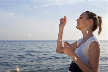 pinchazo - Woman Popping Bubbles on the Beach Foto de stock - Con derechos protegidos, Código: 700-02943246