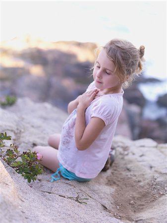 daydreaming (eyes closed) - Young Girl Sitting on Rocks Near the Ocean Stock Photo - Rights-Managed, Code: 700-02954821