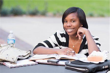 College Student Sitting Outdoors Doing Homework Foto de stock - Con derechos protegidos, Código: 700-02957628