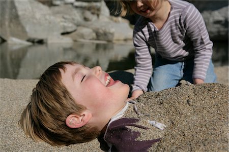 people buried in the sand - Little Girl Burying Brother in Sand Stock Photo - Rights-Managed, Code: 700-02967883