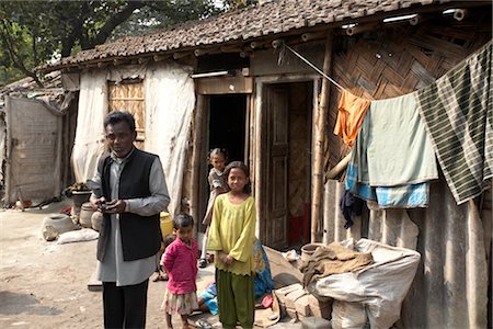 fauchée - Famille à l'extérieur de leur maison, Tilijara, Kolkata, West Bengal, Inde Photographie de stock - Rights-Managed, Code: 700-03004179