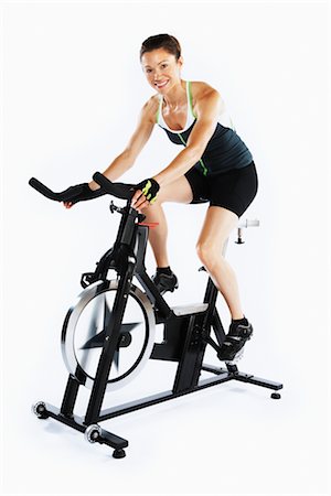 sweaty women - Woman Riding Stationary Bicycle Foto de stock - Con derechos protegidos, Código: 700-03004416