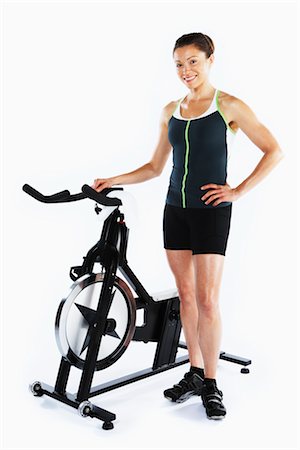 simsearch:700-03004425,k - Femme se tenant près de bicyclette stationnaire Photographie de stock - Rights-Managed, Code: 700-03004411