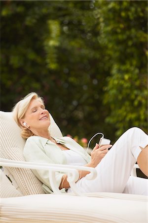 Woman Sitting in Loung Chair, Relaxing and Listening to Music Stock Photo - Rights-Managed, Code: 700-03075332