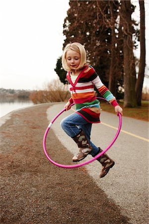 rubber boots young girl - Girl Jumping through Hula-hoop Stock Photo - Rights-Managed, Code: 700-03075867