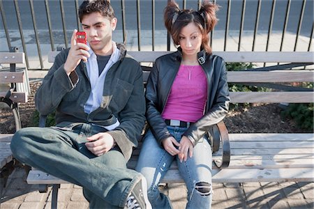 people annoying by phone - Young Couple Sitting on Park Bench Stock Photo - Rights-Managed, Code: 700-03152521