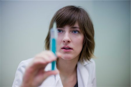 Doctor Looking at Syringe Foto de stock - Con derechos protegidos, Código: 700-03284288