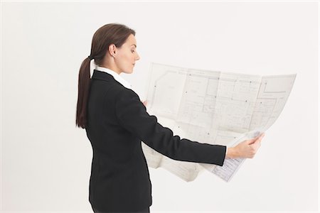 Woman Looking at Blueprints Foto de stock - Con derechos protegidos, Código: 700-03333237