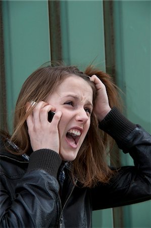 Adolescente en colère parlait au téléphone cellulaire Photographie de stock - Rights-Managed, Code: 700-03454512