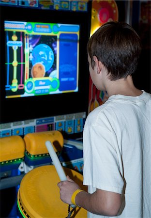 palillo de tambor - Teenage Boy Playing Arcade Game Foto de stock - Con derechos protegidos, Código: 700-03456766