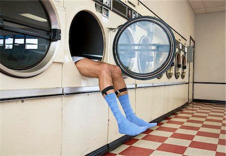 feet man - Man Lying in Clothes Dryer in Laundromat Stock Photo - Rights-Managed, Code: 700-03456964