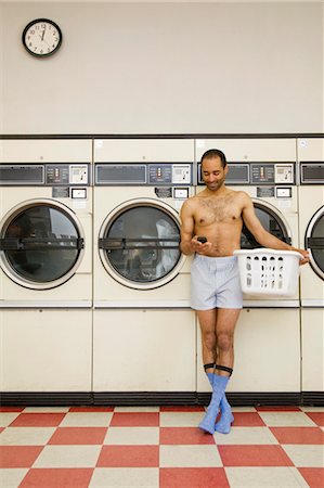 Man Using Cell Phone in Laundromat Stock Photo - Rights-Managed, Code: 700-03456966